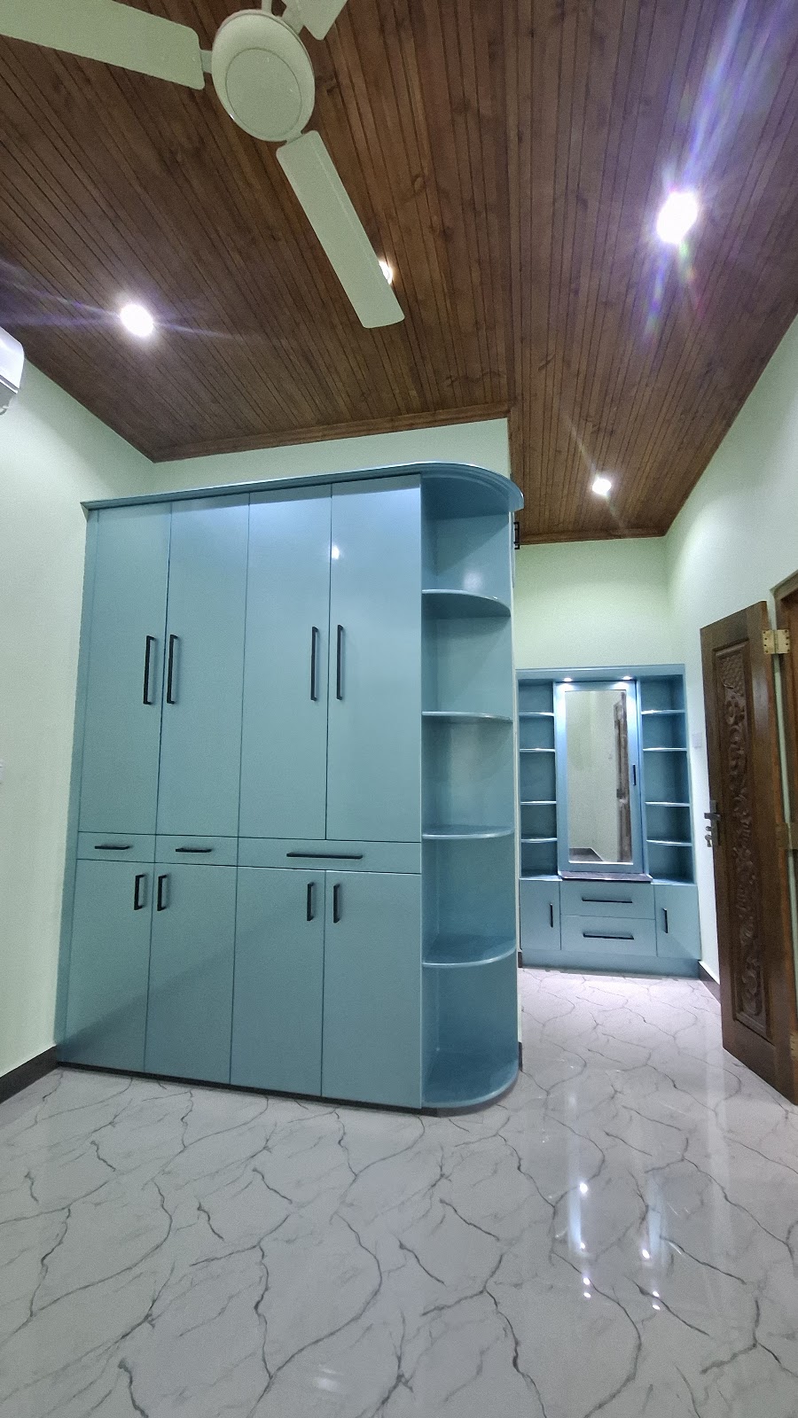 Teal bedroom wardrobe and matching illuminated dressing unit with rounded shelving