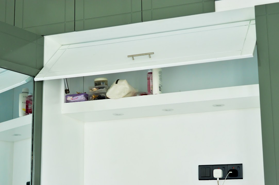 Close-up of hydraulic lift-up overhead cupboard above bedhead