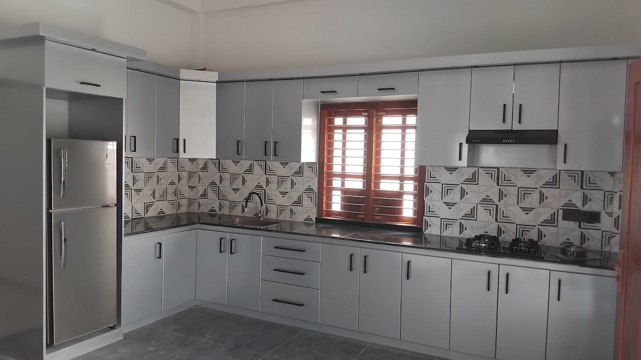Pale fitted kitchen cabinets with a central timber window and geometric tiled backsplash