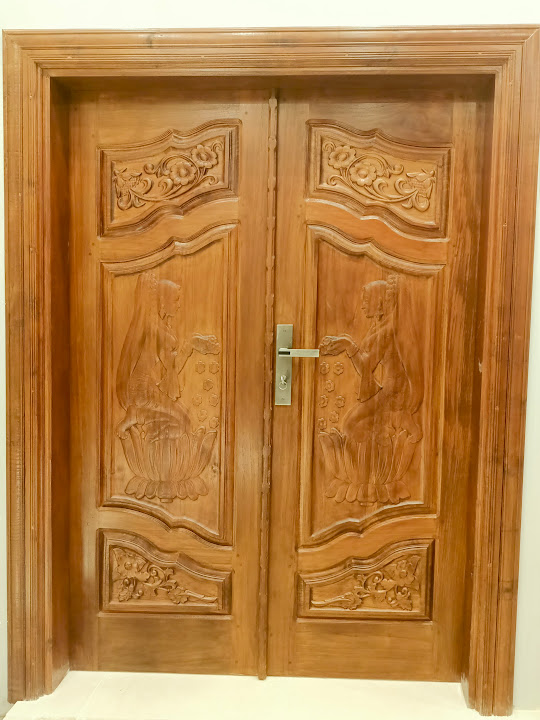Paired timber entrance doors with floral carved panels
