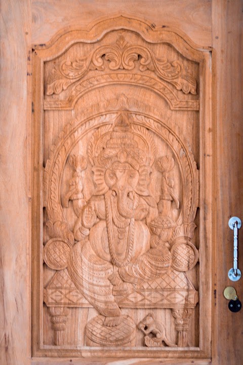 Close-up relief carving of Lord Ganesha, pillar arch, and Kalasam