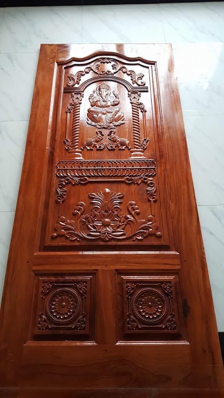 Lord Ganesha carved timber door on workshop floor during final inspection