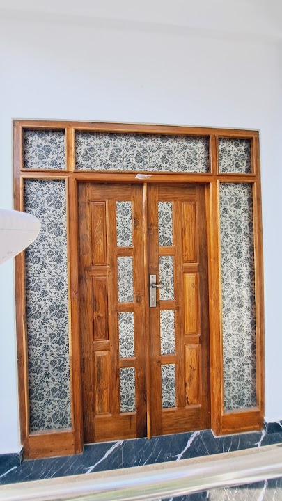 Full exterior front view of grand double entrance door with decorative frosted glass panels and transoms