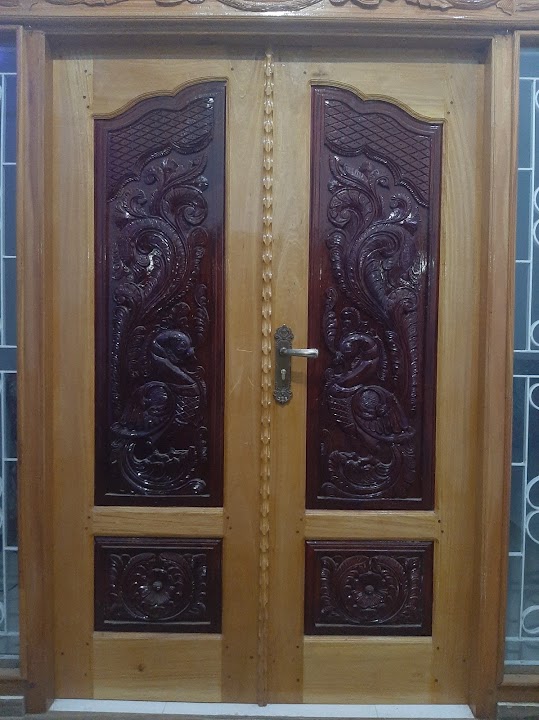 Paired timber entrance doors with dark-stained carved peacock panels and floral rosettes