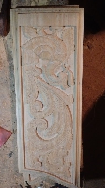 Fine chisel detailing on plumage of carved peacock panel