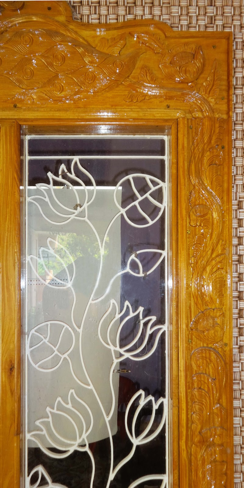 Decorative floral metalwork sidelight within a carved timber frame