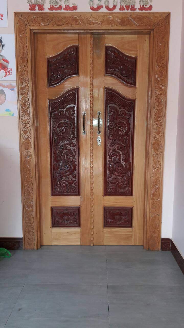 Bespoke Carved Timber Entrance - Artisanal carved entrance door with intricate center relief and elegant frame moldings.