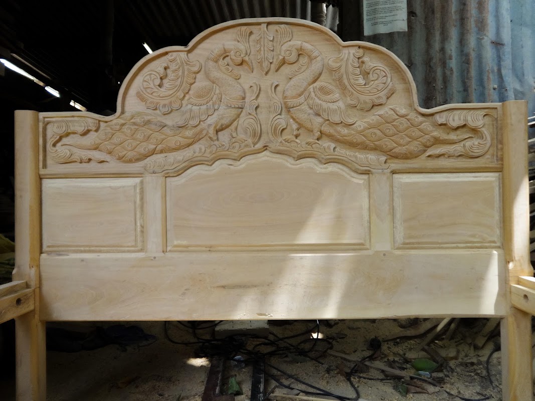 Solid timber master bed headboard deeply carved with mirroring peacocks and floral scrollwork