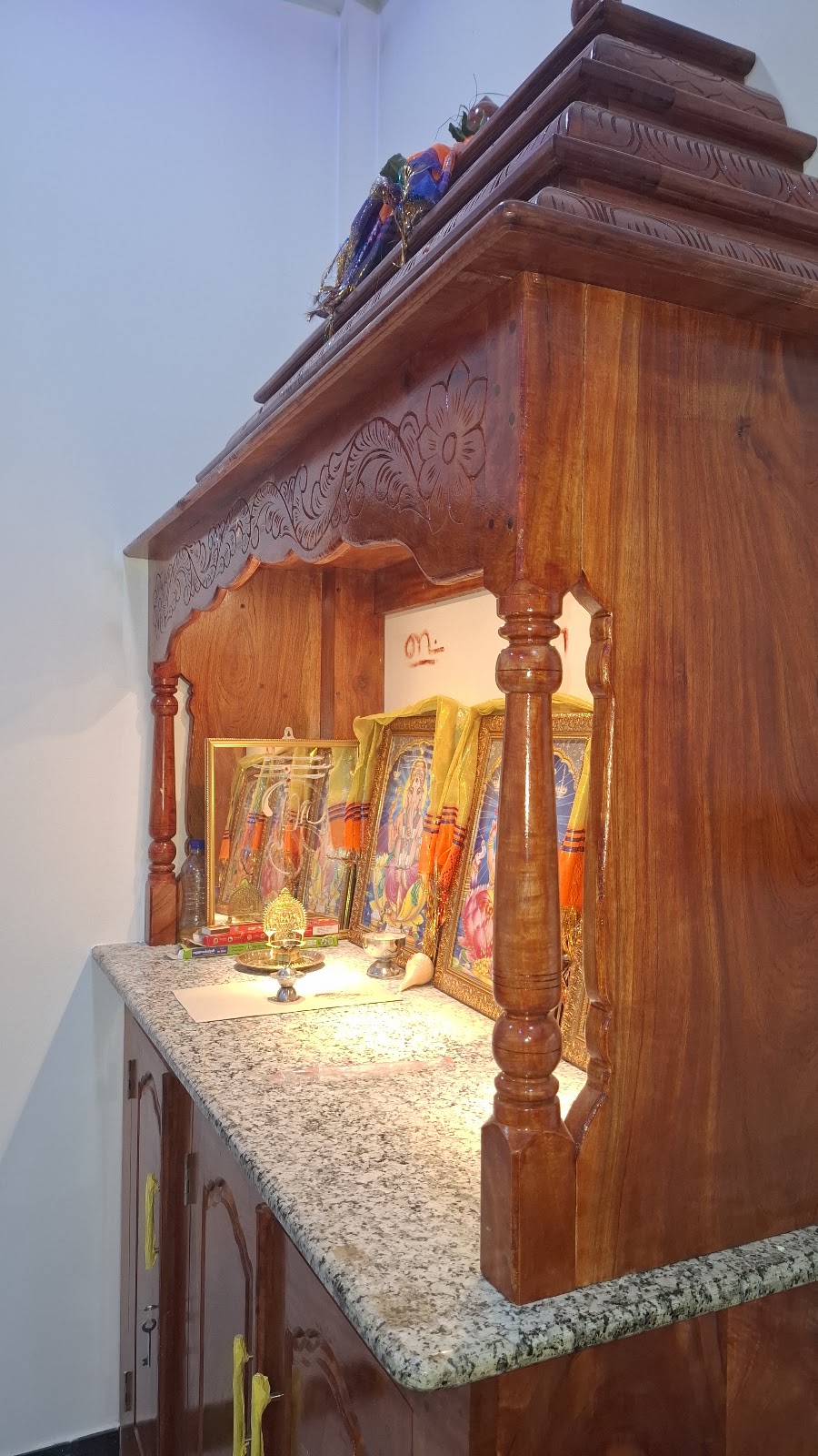 Side view showing the cabinet depth, carved crown, and shrine columns