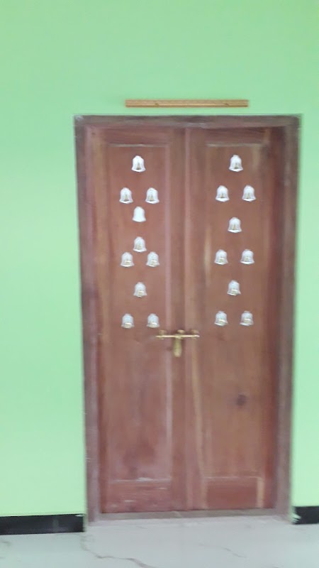 Pooja room timber shrine door with carved mandap arches and hanging brass temple bells