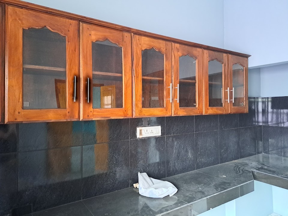 Full length polished granite worktop beneath continuous wall pantry cabinets