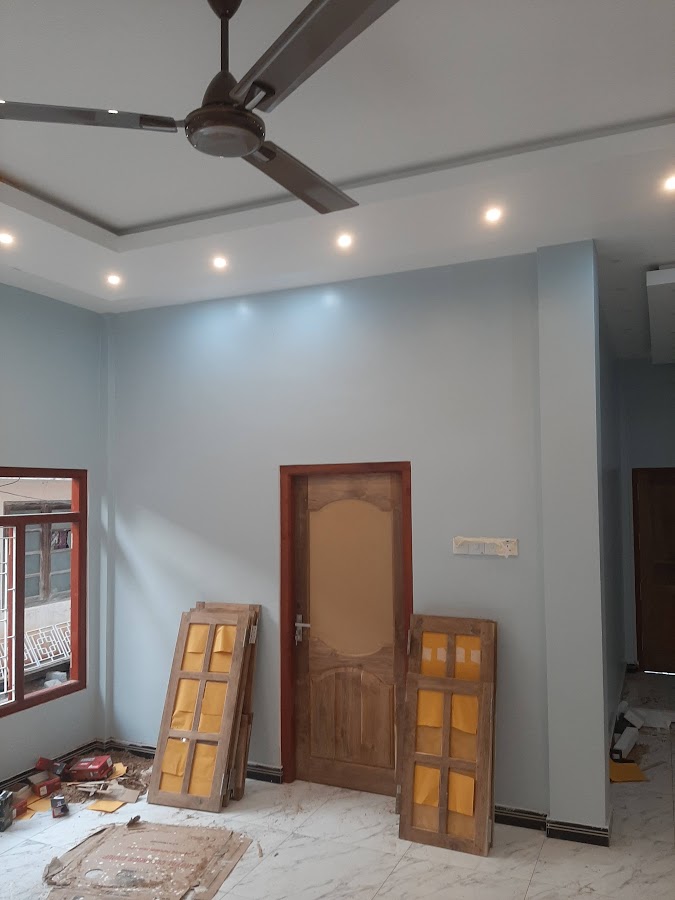 Finished modern living hall with recessed stepped gypsum tray ceiling, downlights, and timber doors