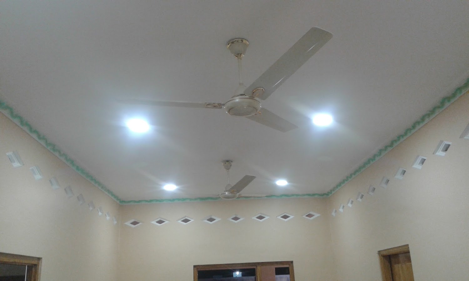 Classic perimeter false ceiling with soft warm downlights illuminating hall walls