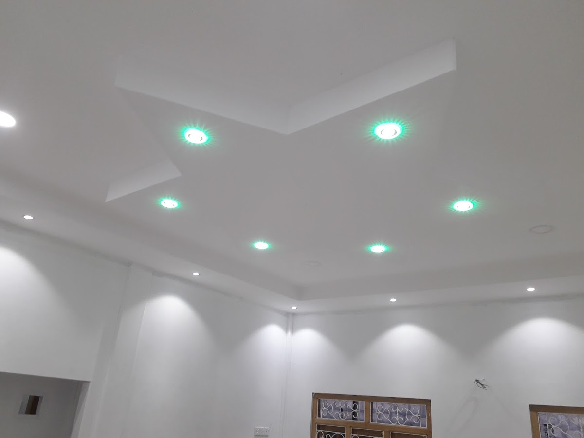 Wide room view showing illuminated false ceiling above tiled floor
