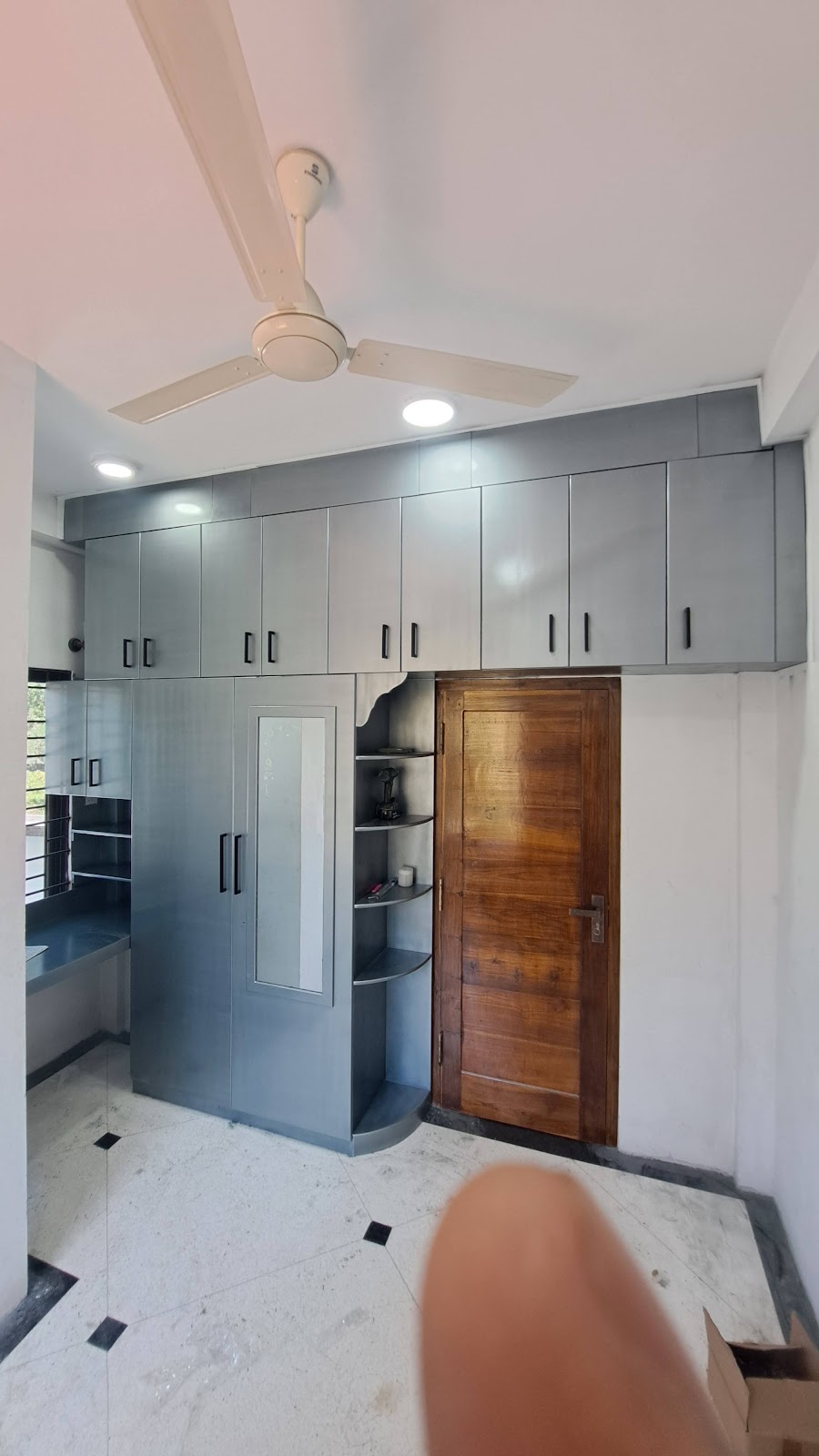 Full-height grey pantry cabinets arranged around a timber doorway