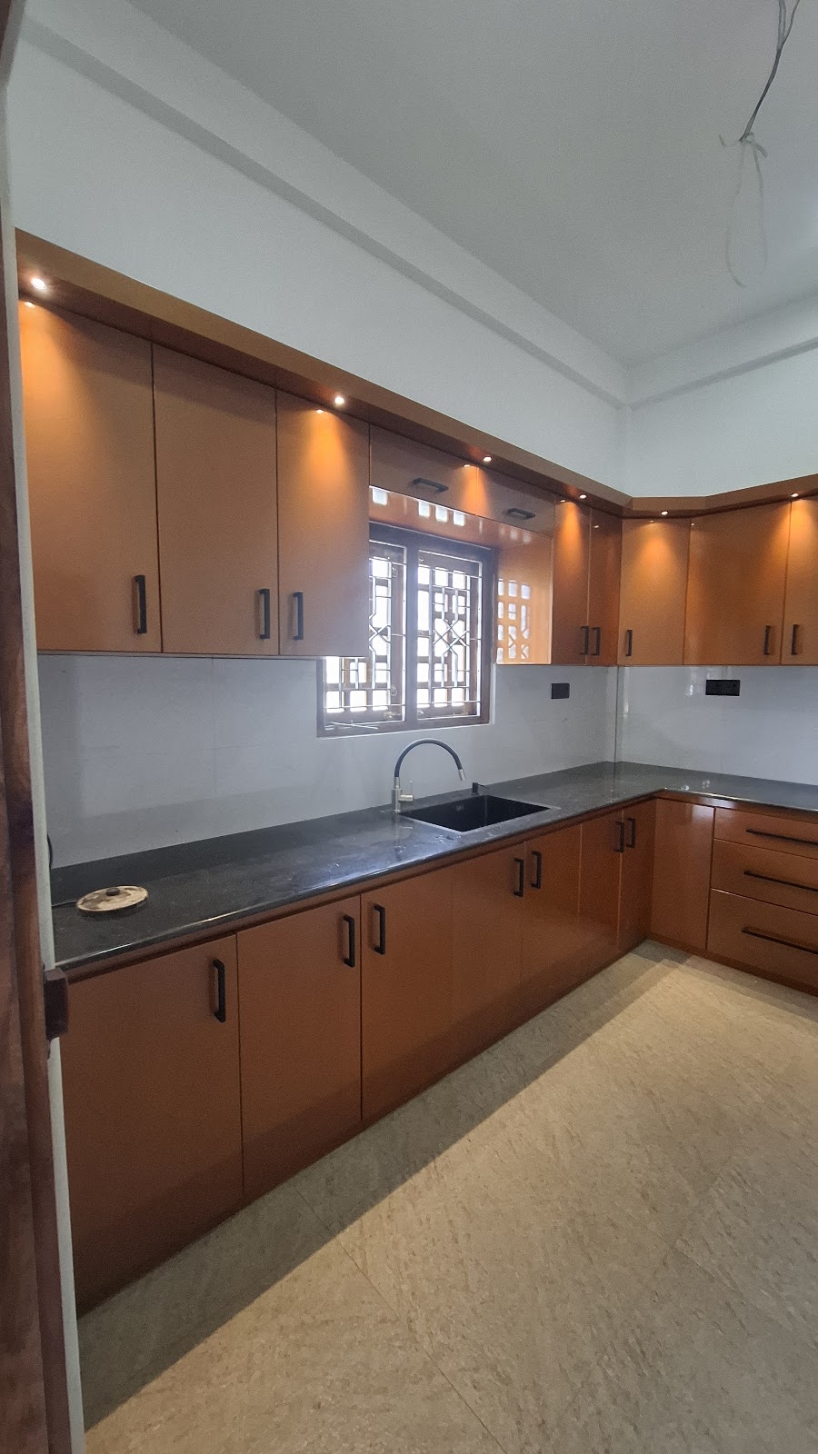 Angled view along the dark worktop and illuminated upper cabinets