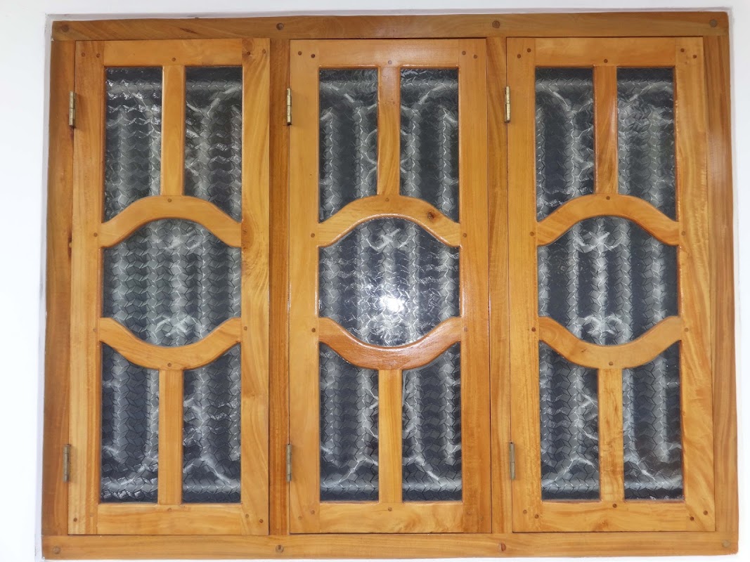 Three-sash timber window featuring organic wave curved mullions and glazed panes
