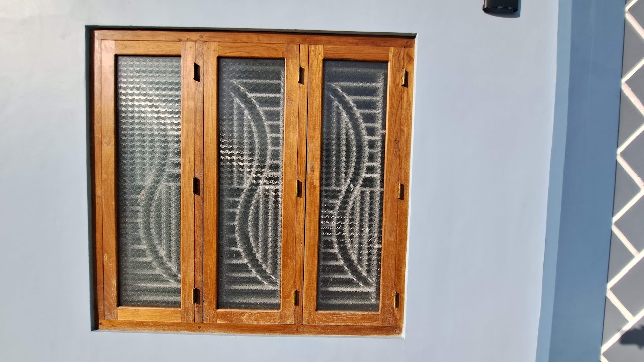 Three-section timber window with curved detailing and textured glass