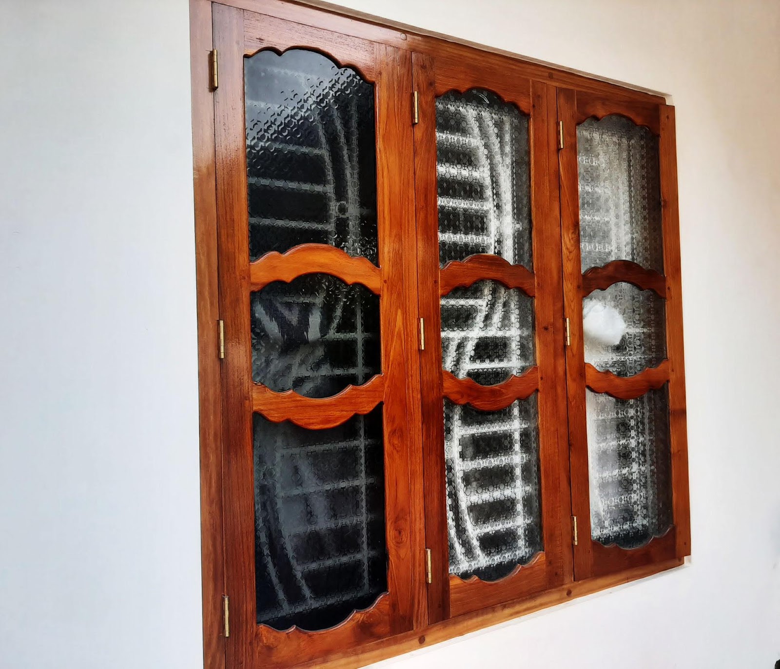 Angled view showing the depth of the timber frame and curved grille pattern