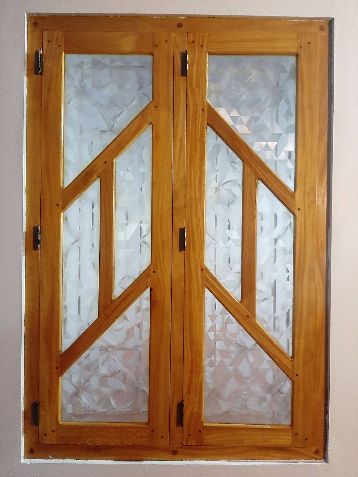 Paired timber window with mirrored diagonal rails and textured glass