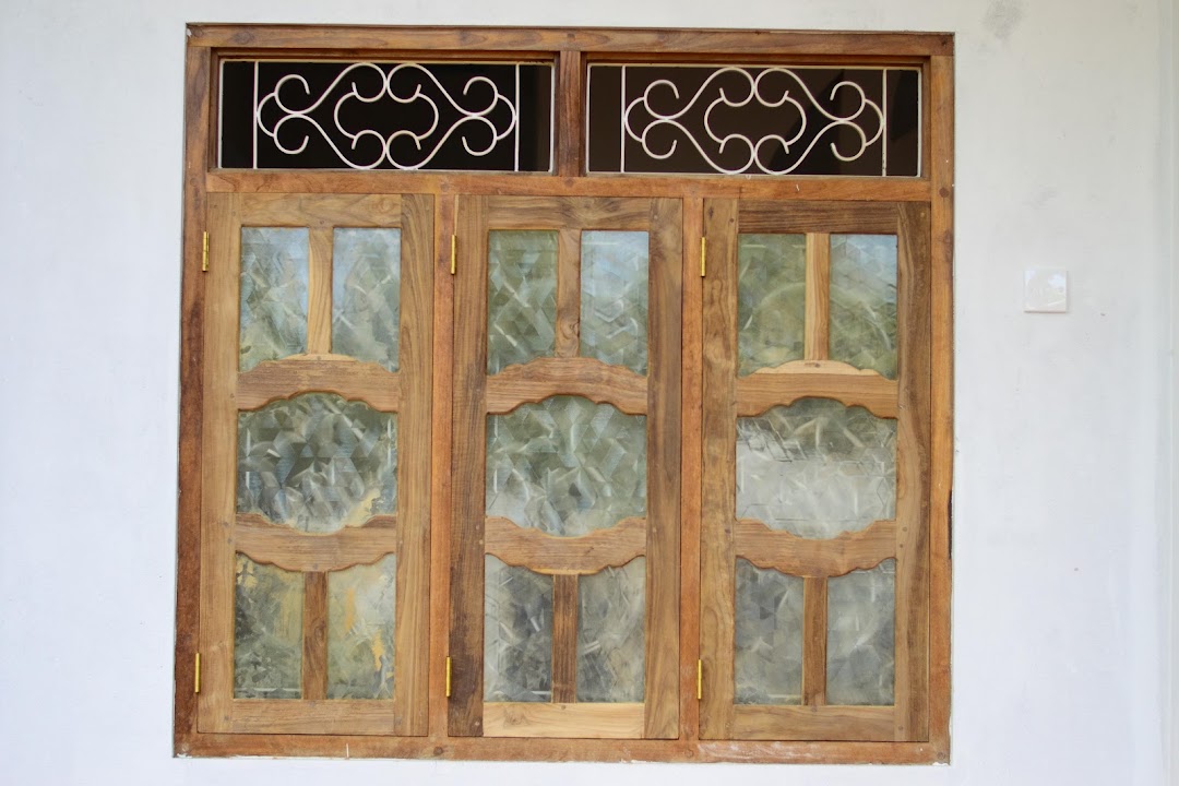 Three-section timber window with curved cross rails and scrollwork wrought iron in upper transom